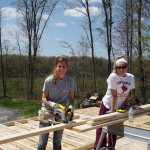 Two women are working on a building project.