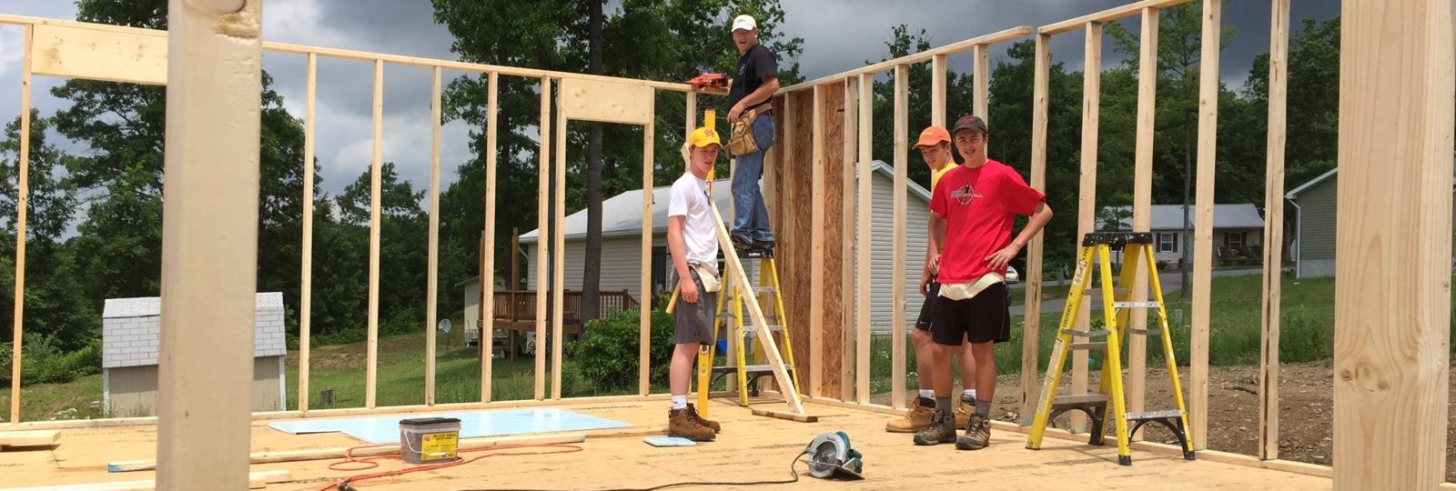 A group of people standing around building construction.